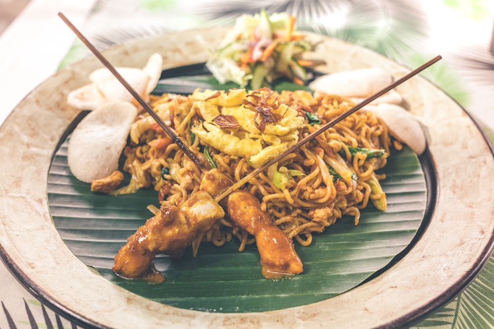 A plate of stir-fried noodles with vegetables and meat